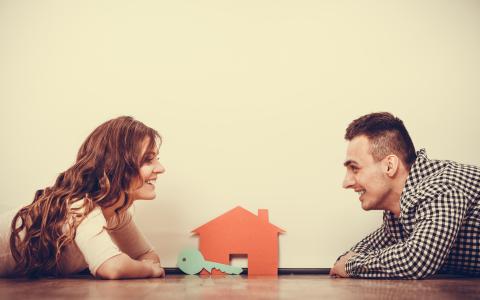 Couple on floor with model house and key